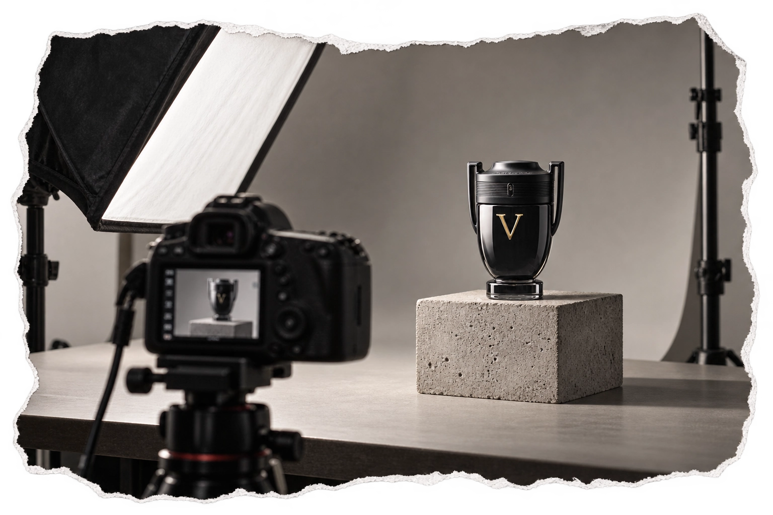 Invictus perfume bottle photographed on a concrete pedestal in a professional studio.